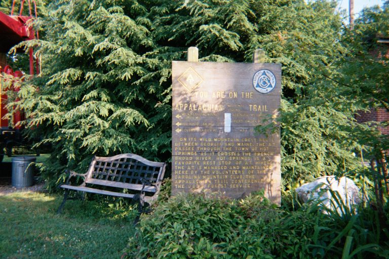 
An AT sign at Hot Springs, NC.  A branch is blocking the part that says 
``Springer Mountain, 271 mi''.  I guess it would be out of focus anyway.
