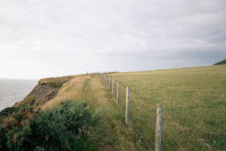 
This is th trail that goes along the cliffs in Wales.  It's rather precarious.
A barbed-wire fence on your right, and cliffs on your left, and sometimes you
get about a foot or two in between.
